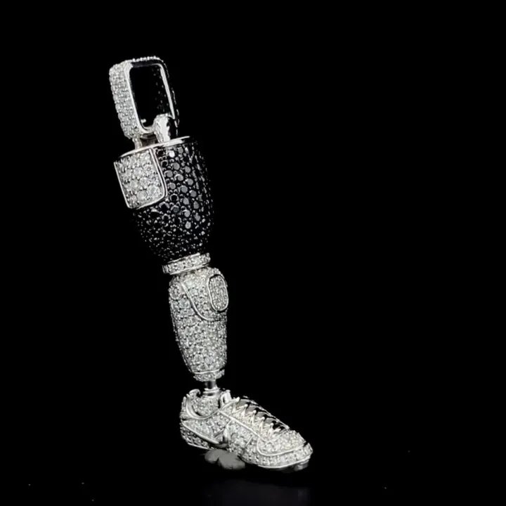 One-of-one iced-out prosthetic leg pendant in black and white stones by Goldlinx Jewelry