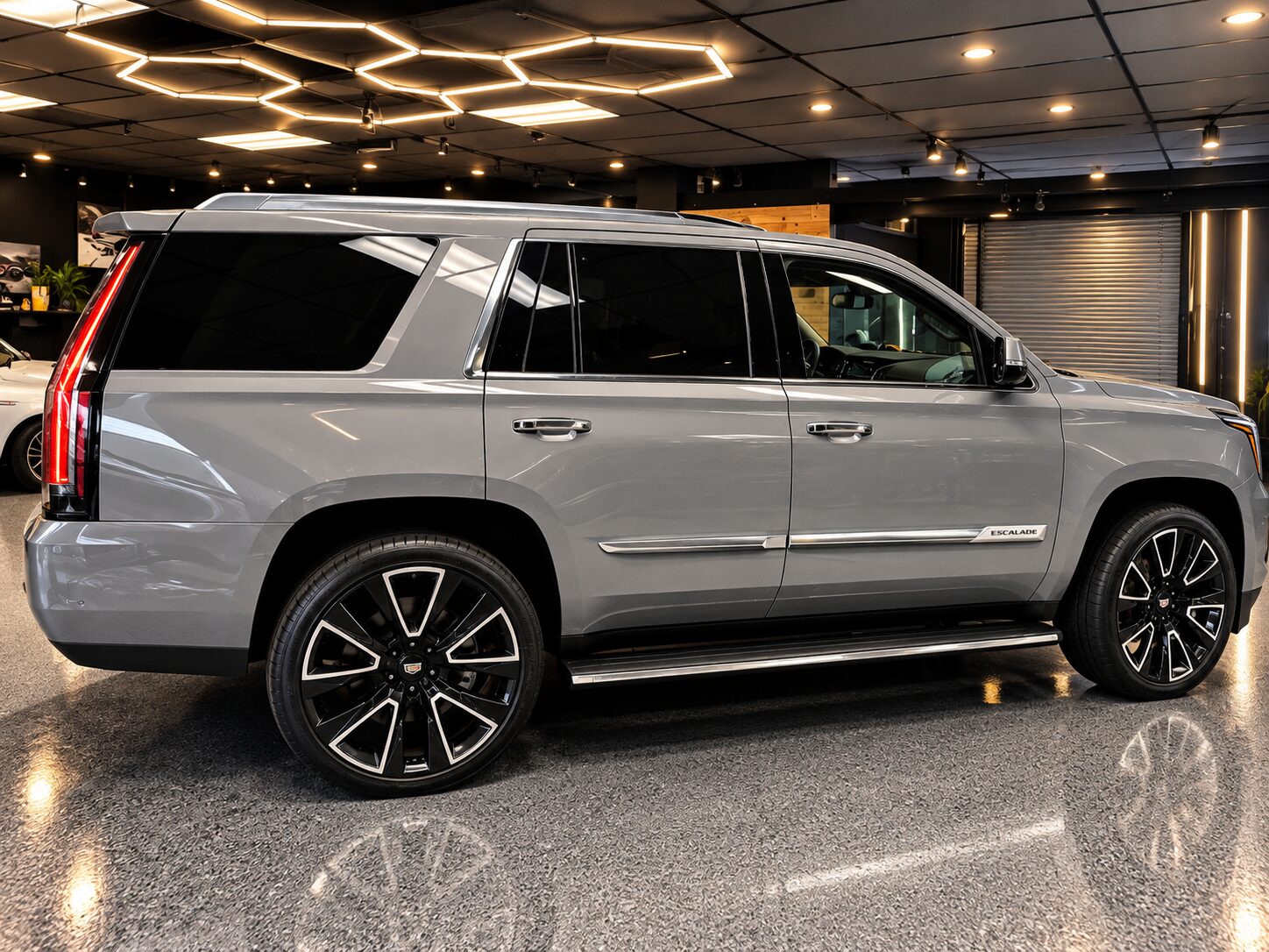 Cadillac Escalade after a full gloss Nardo Gray vinyl wrap, side profile in our Costa Mesa showroom